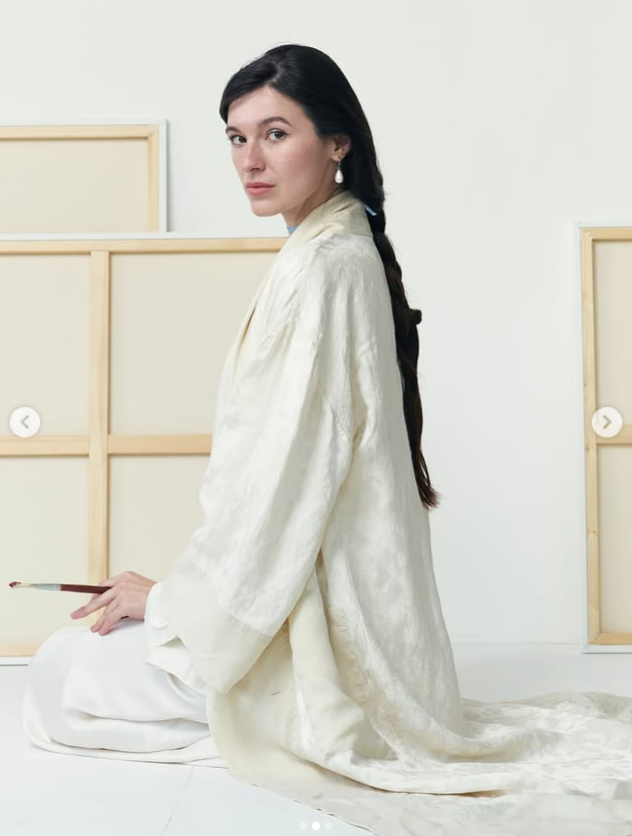 Artist Sisi in her studio surrounded by original paintings