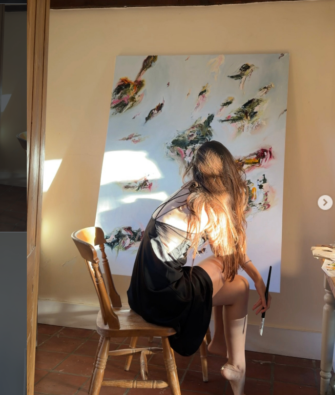 Artist Sisi painting a large abstract artwork in her studio